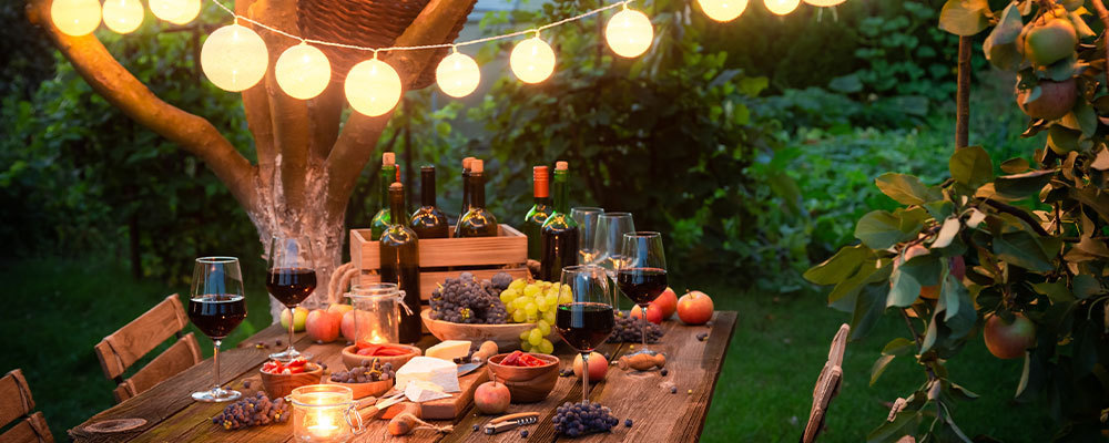 Food on a table at twilight with fairy lights
