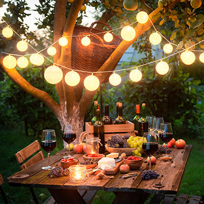 close up of food on a table at twilight with fairy lights