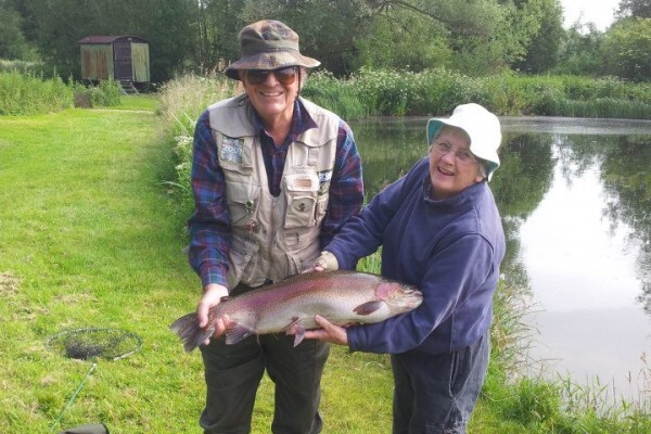 Man and lady holding rainbow trout